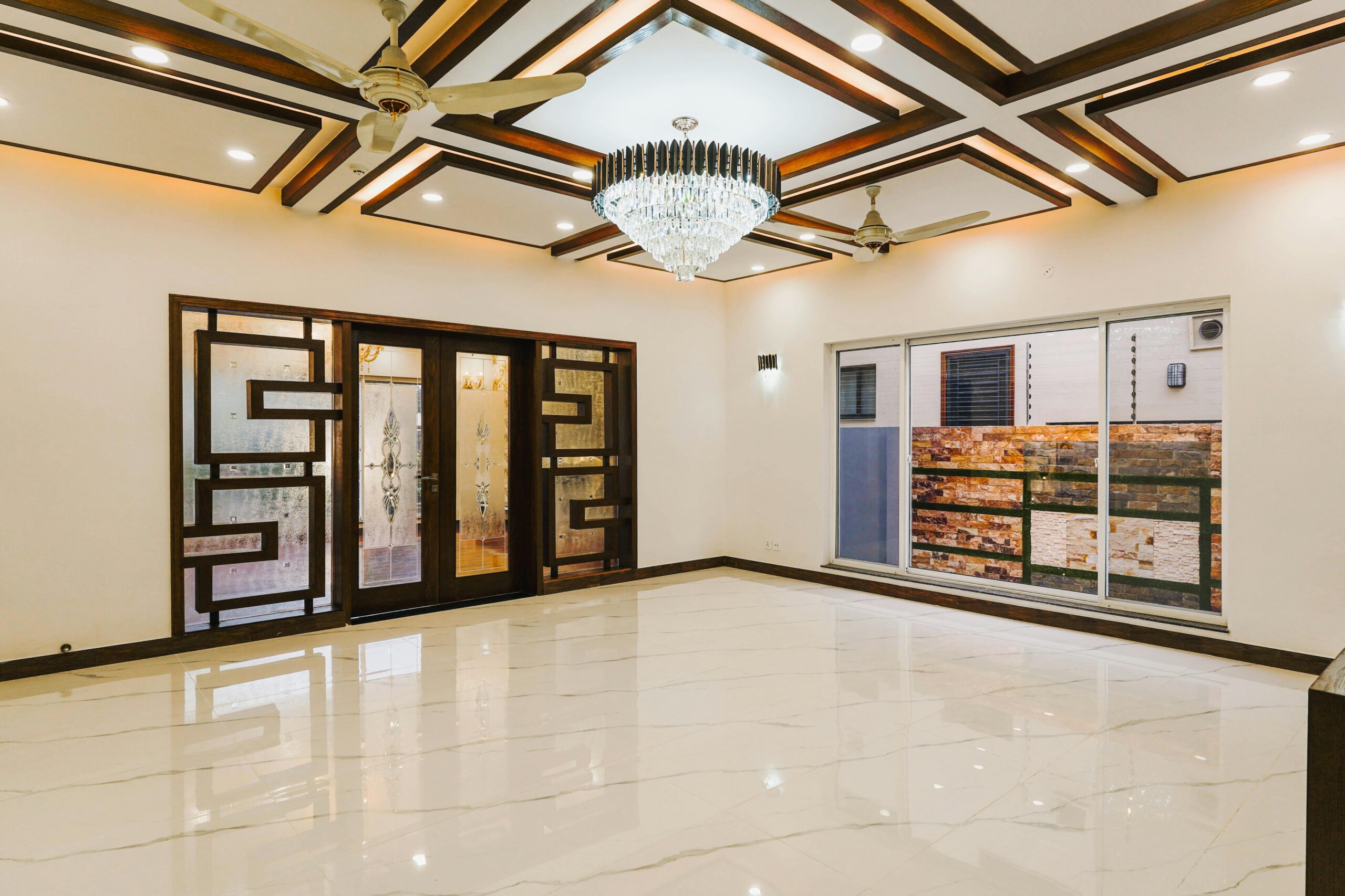 Spacious luxury room with ornate doors and marble flooring.